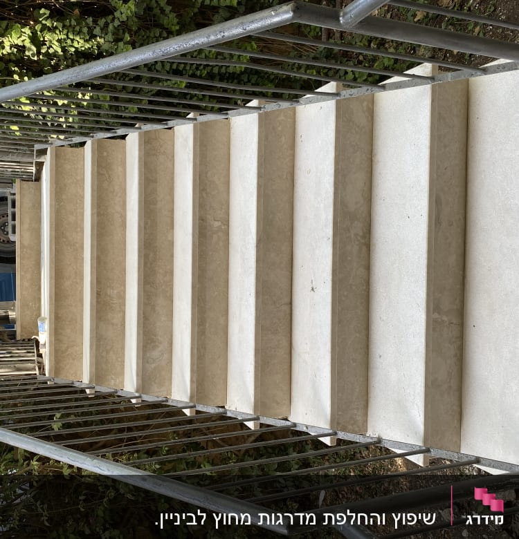 מדרגות שיש עם מעקה מתכת בשיפוץ